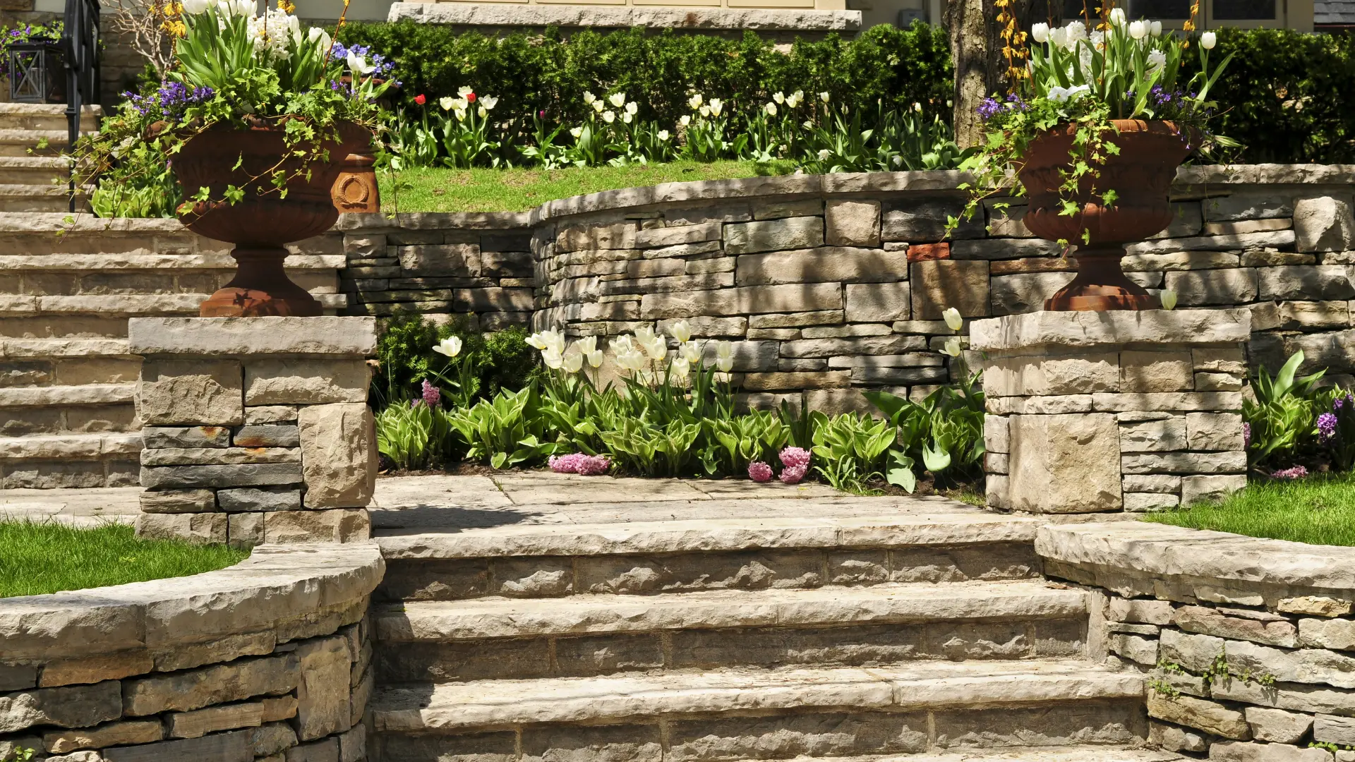 A beautifully maintained natural stone walkway surrounded by lush greenery.